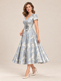 Detailed view of blue and champagne-toned floral pattern on formal midi dress