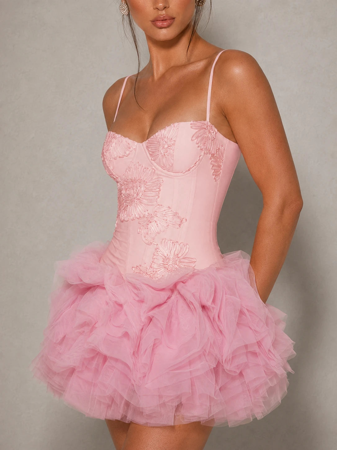Close-up of the sweetheart corset bodice and tonal floral applique on the Fiora pink mini dress