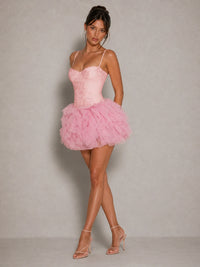 Full-length side view of the Fiora pink corset mini dress with slender straps and tulle ruffle skirt
