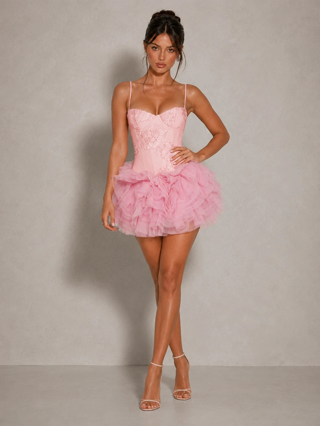 Three-quarter view of the Jovellee Fiora pink floral applique corset mini dress with voluminous mesh ruffles