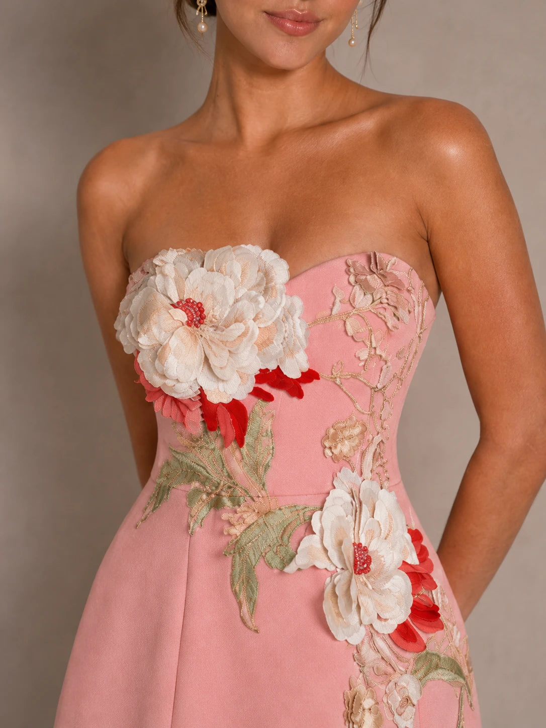 Close-up of the Isadora pink strapless dress with oversized 3D flower applique and embroidered leaves