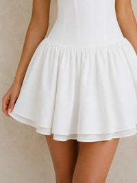 Close-up of the Jovellee Lisette white chiffon mini dress with a fitted corset waist and layered A-line skirt