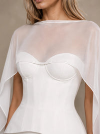 Close-up of the sheer bridal cape and structured corset bodice on the Seraphina wedding dress