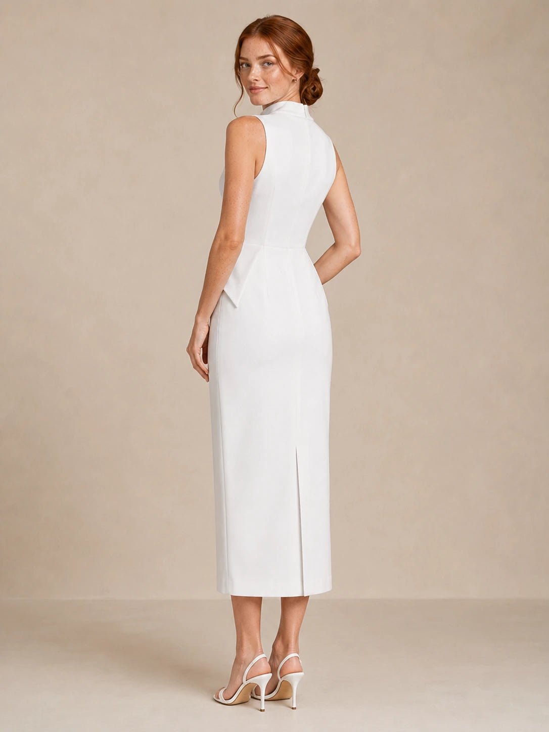 Back three-quarter view of the Jovellee Solenne white high-neck wedding dress with a fitted column silhouette and back slit