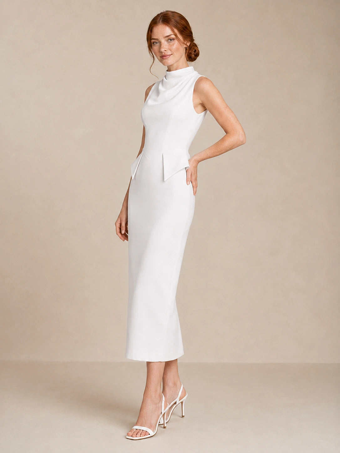 Three-quarter front view of the Jovellee Solenne minimalist white wedding dress with sculptural peplum waist detail