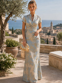 Full-length dusty blue floral jacquard mother of the bride dress with flattering wrap waist and short sleeves for weddings.